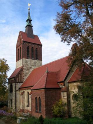 Aussenansicht Kirche mit Begrünung im Sommer.