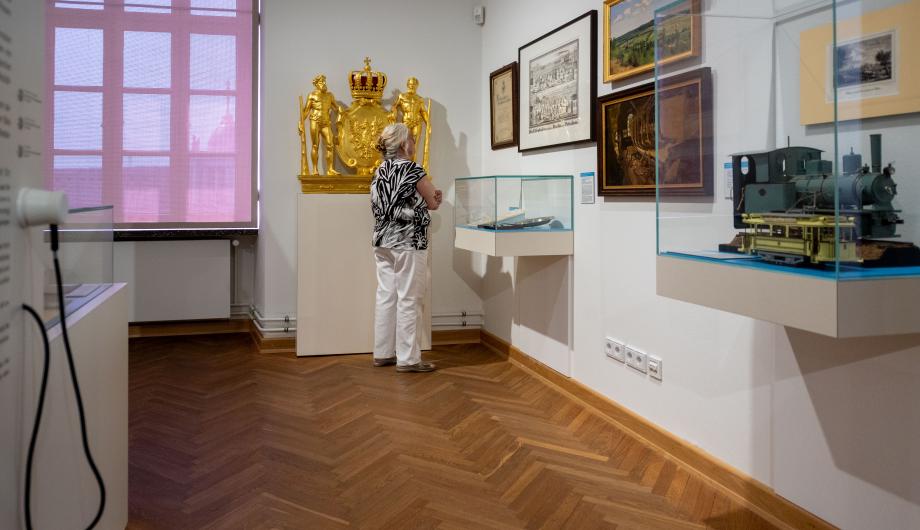 Potsdam Museum eine Frau besucht die Dauerausstellung und schaut sich ein Objekt genauer an Ausstellung
