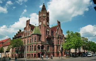 Aussenansicht des Kulturhaus Babelsberg ehemaliges Babelsberger Rathaus. In der Mitte des vierstöckigen roten Klinkerbaus ragt ein Turm an der Straßenkreuzung Karl-Liebknecht- und Rudolf Breitscheid-Straße.
