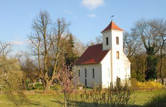 Dorfkirche mit Parkanlage im Frühling.