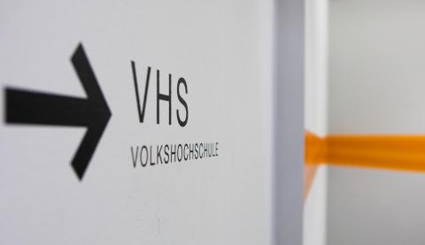 Ein Wegweiser mit Pfeil im Treppenhaus der VHS.